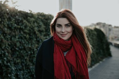 Güzel genç bir kadın kameraya gülümsüyor. 