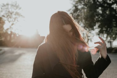 Kafasını sallayarak uzun kızıl saçlı kız