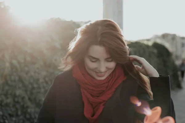 Woman looking down, toucing her hair and smiling