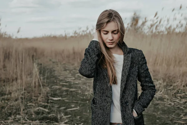 Verlegen vrouw permanent op de achtergrond van de Lisdodde — Stockfoto