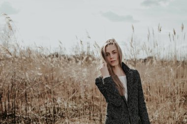 Kameraya bakarak ve saçları için dokunaklı güzel kadın