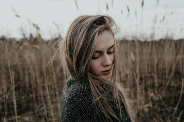 Onu kollamaya yün ceket giymiş uzun sarı saçlı güzel kadın