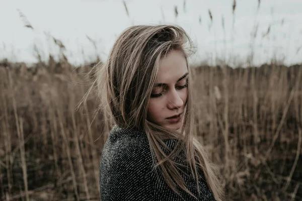 Onu kollamaya yün ceket giymiş uzun sarı saçlı güzel kadın