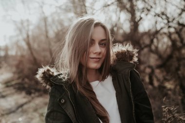 Kukuleta ile yeşil sıcak ve açılarak ceketli kamera poz kadın