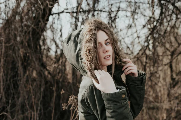Vrouw gekleed in warme winter jas met bont capuchon op zoek in de camera — Stockfoto