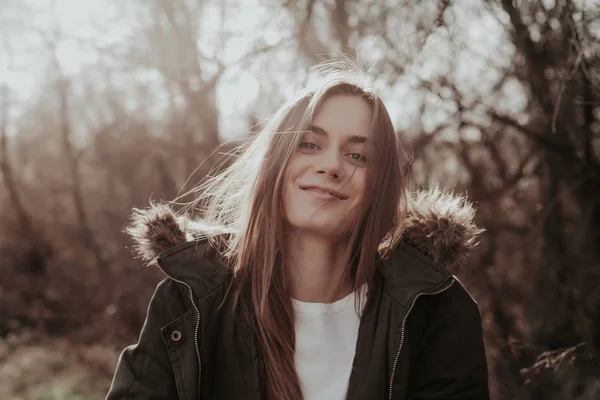 Vrouw in groene jas met kap bont camera kijken en glimlachen — Stockfoto