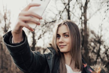 Kadın akıllı telefondan selfie çekiyor.