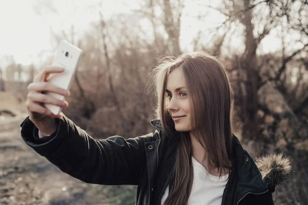 Kadın akıllı telefondan selfie çekiyor.