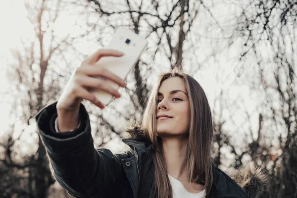 Kadın akıllı telefondan selfie çekiyor.