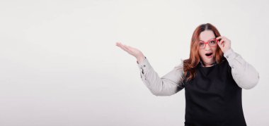 İyi beslenmiş rakam sağ tarafında bir şey üzerinde işaret eden kadınla \ artı boyutu model sürpriz bakışla kameraya bakıyor. Bir çok kopya yer.