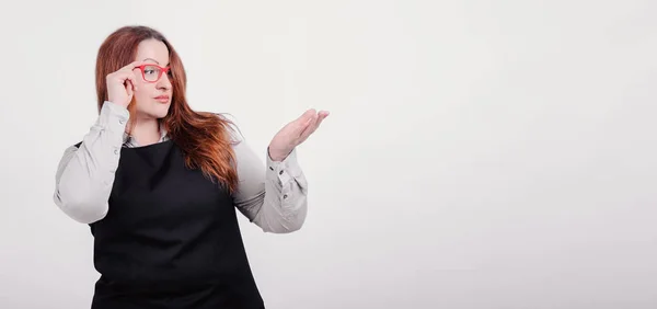 İş kadını ile iyi beslenmiş vücut sağ tarafında ve kendinden emin bir görünüm ile bir şey liiking işaret. Artı boyutu model Studio beyaz arka plan üzerinde fotoğraf makinesinde poz. Kopya alanı