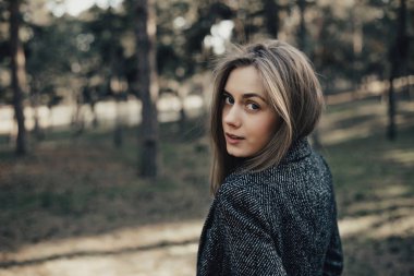 Sarışın kız park kamera poz. Kameraya onu kollamaya modeli