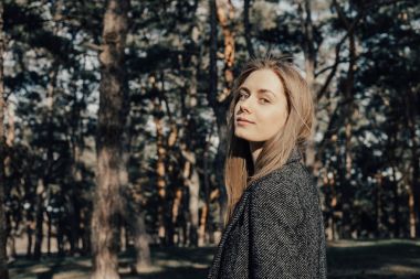 Sarışın kadın kameraya poz arka plan açık ağaç 