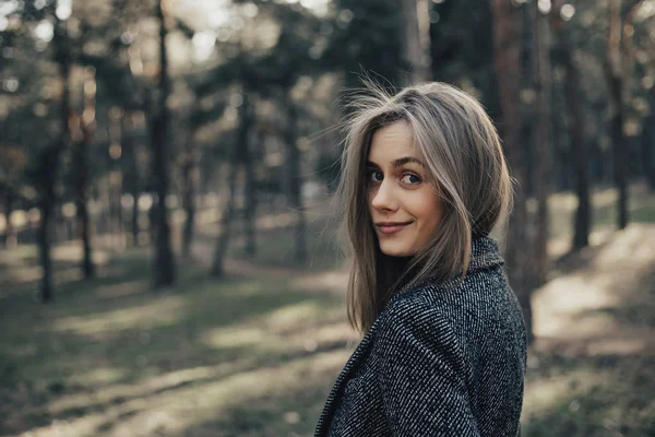 Onun omuz kameraya bakarak uzun sarı saçlı kendine güvenen kadın