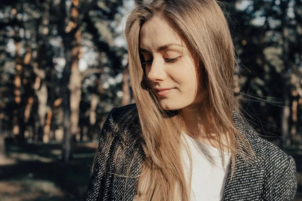 Uzun sarı saçlı genç ve güzel kadın portresi. Güneş ışığı. Açık