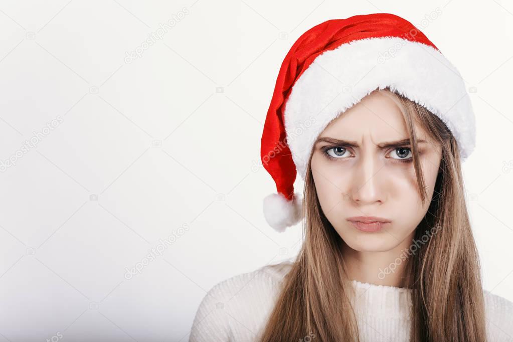 The young woman in santa hat with bad mood make capricious face