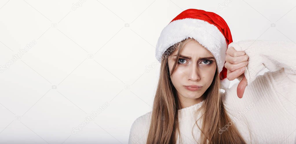 The girl in santa hat shows thumbs down