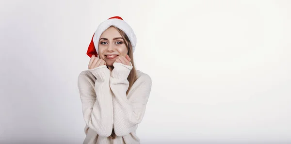 快乐的女孩在圣诞老人的帽子想象她的圣诞礼物 — 图库照片