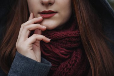 Aşırı dolgun dudaklar younge güzel kadınla portresi kapatın. Onun yüz ve dudak sağ dokunmadan kız. Fotoğrafta kadın yüzü alt kısmında tasvir. Paltonu ve kaşkolünü giyen kadın.