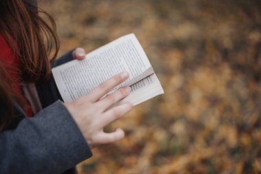 Kadının ellerini ve o sayfa leafing açık bir kitap vardır. 