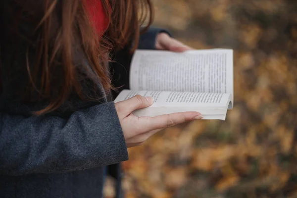 Tutan kadın kitap açtı. Okuma outdooron sonbahar park modeli. Sonbahar. Açık.