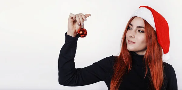 Feliz Joven Pelirroja Sombrero Santa Sosteniendo Mano Una Pequeña Bola —  Fotos de Stock