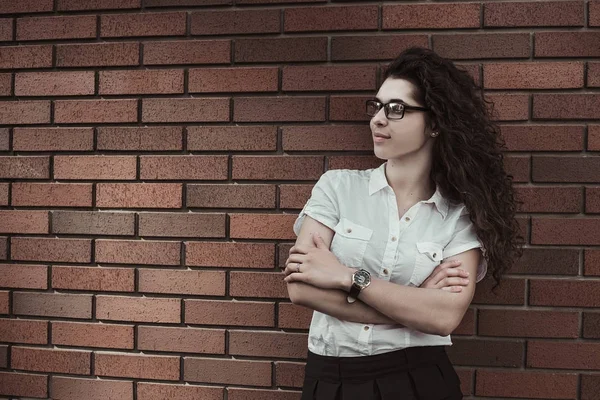 Genç ama kendine güvenen kadın siyah kıvırcık saçlı inci kırmızı duvar arka plan üzerinde duran ve yan arıyorum