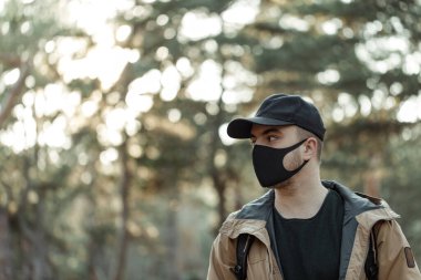 Tıbbi maskeli adam yana bakıyor.