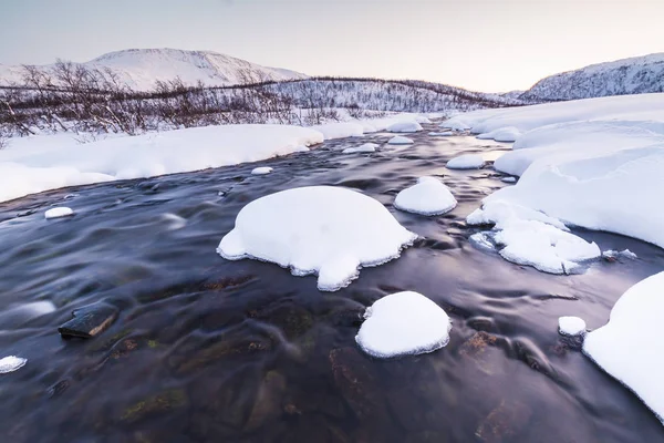 Alacakaranlık bir kış peyzaj taşları ile su akışı. — Stok fotoğraf