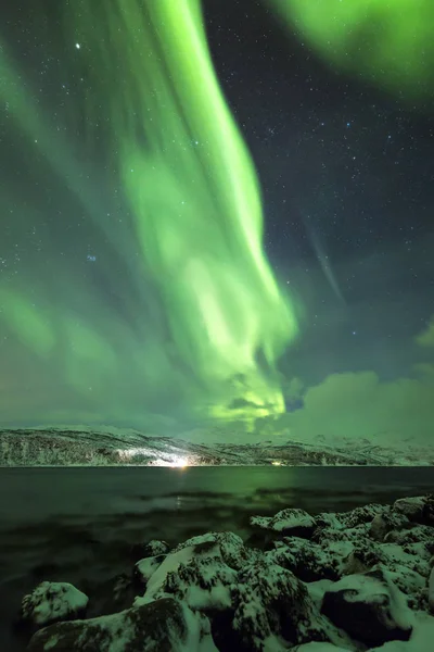 Norrsken, aurora borealis, ovanför en fjord omgiven av en — Stockfoto