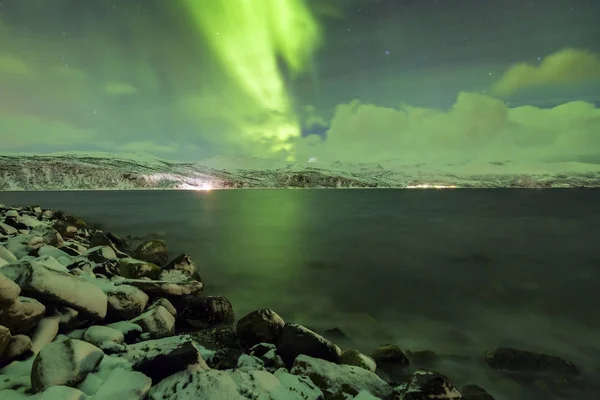 Norrsken, aurora borealis, ovanför en fjord omgiven av en — Stockfoto