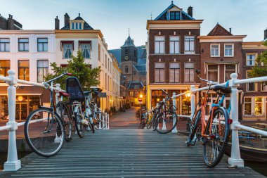 Leiden'de alacakaranlıkta geleneksel Hollanda kültür evleri ve kanalı