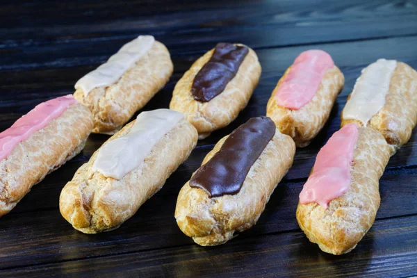 Eclairs on wooden background — Stock Photo, Image