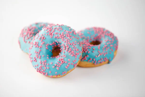 Donut com esmalte azul e granulado rosa isolado sobre fundo branco. Vista superior . — Fotografia de Stock