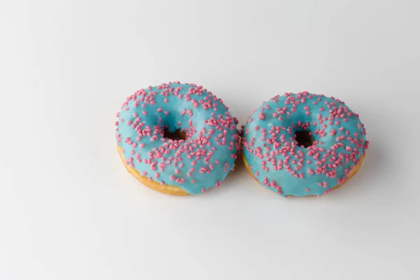 Donut mit blauer Glasur und rosa Streusel isoliert auf weißem Hintergrund. Ansicht von oben. — Stockfoto