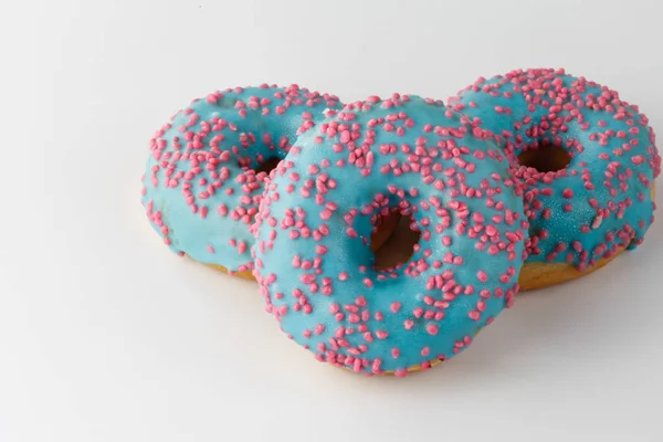 Donut com esmalte azul e granulado rosa isolado sobre fundo branco. Vista superior . — Fotografia de Stock