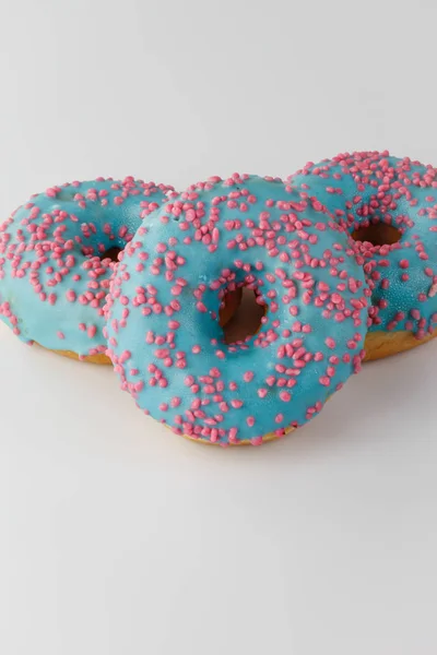 Donut con esmalte azul y salpicaduras de color rosa aisladas sobre fondo blanco. Vista superior . — Foto de Stock