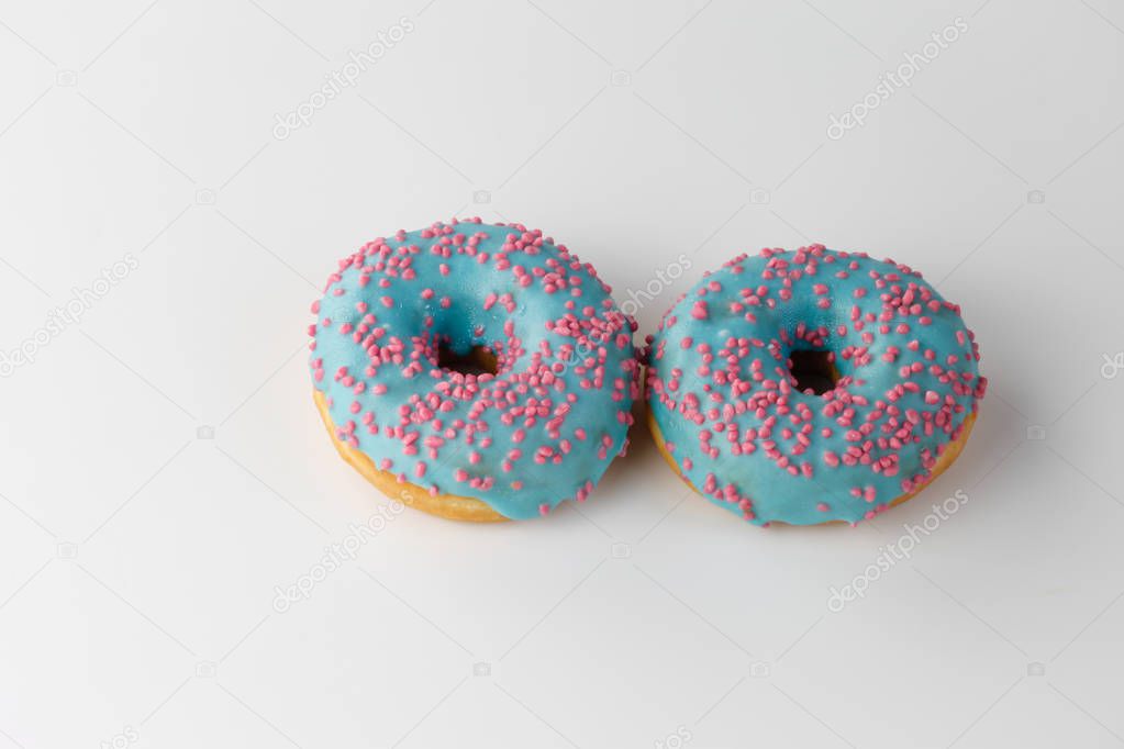 Donut with blue glaze and pink sprinkles isolated on white background. Top view.