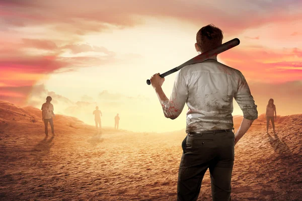 Man with bat against zombies in desert — Stock Photo, Image