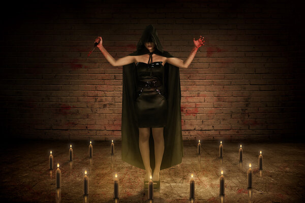 Scary asian witch woman with bloody knife and hand standing on the center of circle candle in the dark room