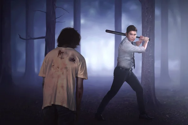 Asian man killing zombie with bat — Stock Photo, Image