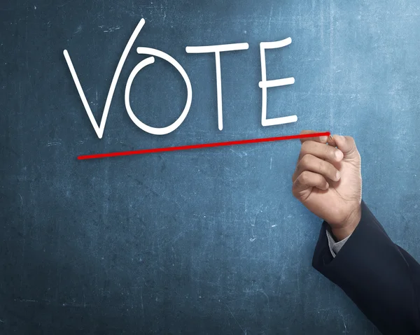 Hand with vote sign on chalkboard — Stock Photo, Image