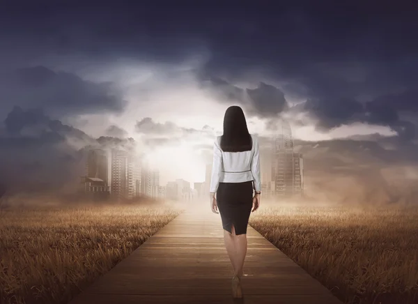 Businesswoman walking to modern city — Stock fotografie