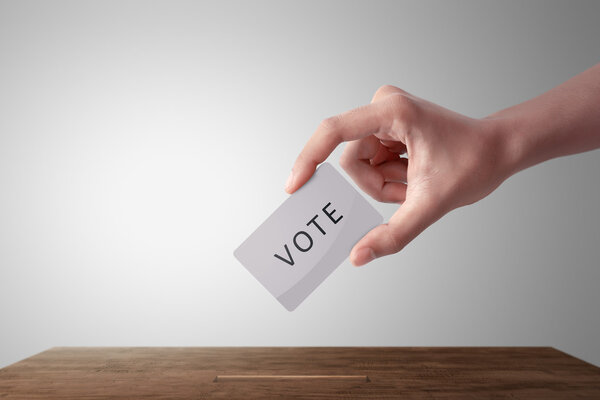 рука с бюллетенем в день выборов
