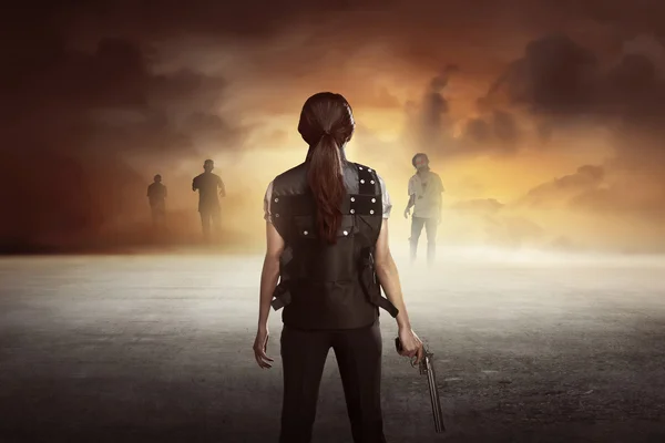 Woman with gun against zombies — Stock Photo, Image