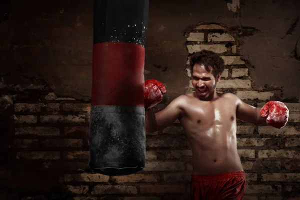 Asiatiska manliga boxare tränar med en slagsäck — Stockfoto