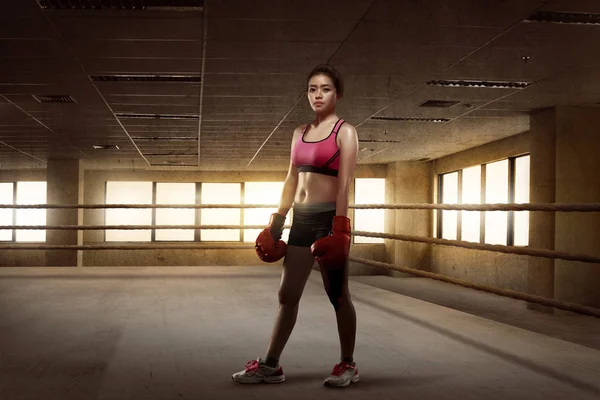 Güzellik Asyalı kız boksör ile kırmızı eldiven boks ringde ayakta — Stok fotoğraf