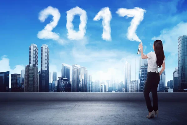 Woman spraying white 2017 cloud — Stock Photo, Image