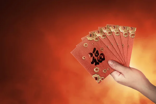 Рука держит китайские красные конверты — стоковое фото