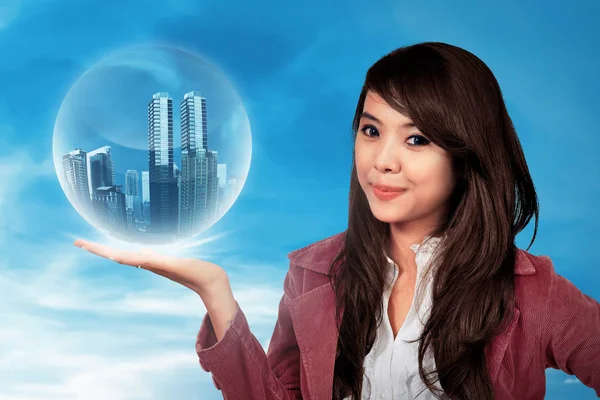 Asian woman holding building in sphere — Stock Photo, Image